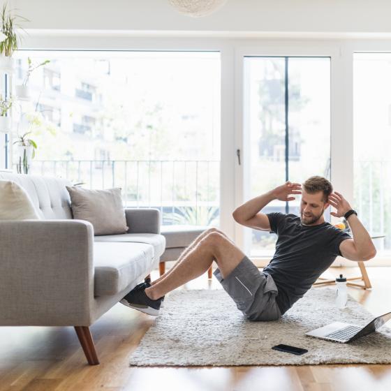 En man gör sit-ups i vardagsrum