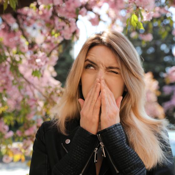 Kvinna står under ett träd som blommar