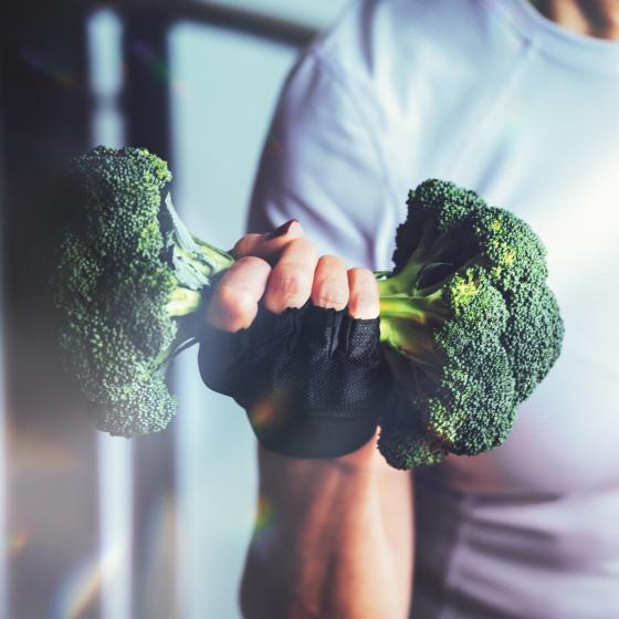 Broccoli buketter som en hantel i en hand