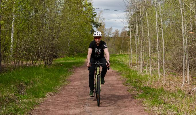 Roger på cykel påväg upp för en backe.
